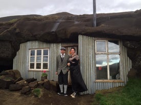 A couple in traditional clothing outside the Laugarvatnshellar cave house.