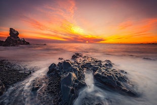 Shades of pink and orange fill the sky as the sun sets over the dramatic coastline of the Snæfellsnes peninsula.