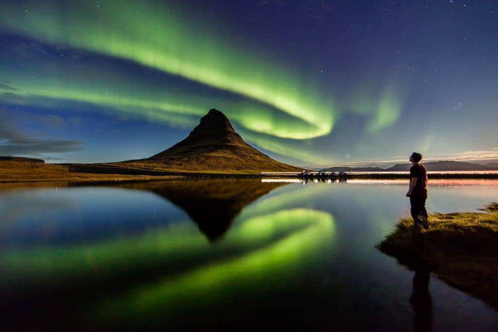 Kirkjufell-vuori Snæfellsnesin niemimaalla revontulten loisteessa.