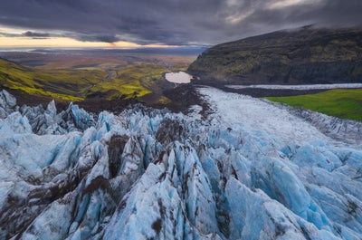 Groene flora, witte gletsjer en donkere bergen in het natuurreservaat Skaftafell.
