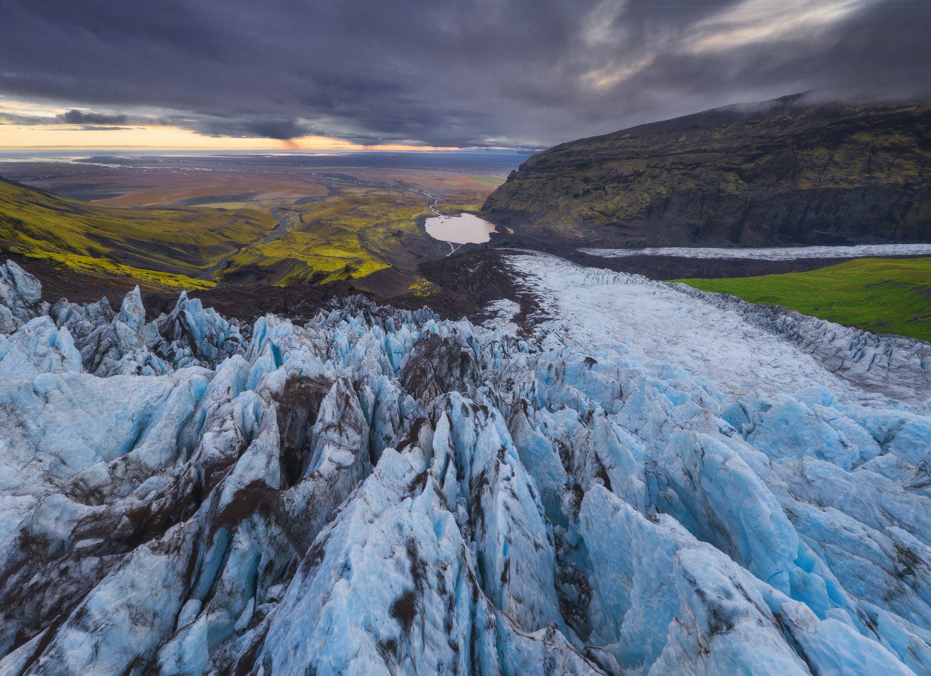 Végétation verte, glacier blanc et montagnes sombres dans la réserve naturelle de Skaftafell.