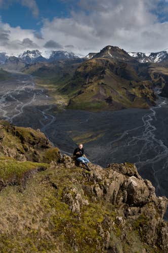 An adventurer poses for a photo atop a mountain peak in Thorsmork.