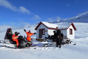 A group of snowmobilers resting in a mountain hut near Akureyri.