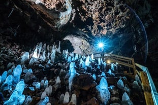 Stalagmites dans la grotte de lave de Vidgelmir, en train de briller dans la lumière tamisée.