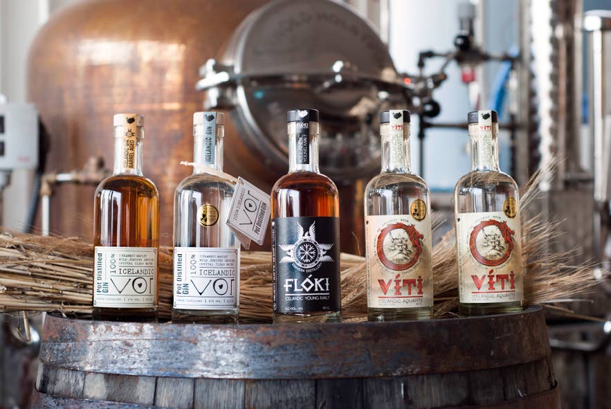 Bottles of Eimverk's Floki whiskey, Vor gin, and Viti brennivin on a barrel at the distillery near Reykjavik.