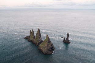 レイニスドランガル（Reynisdrangar）の奇岩群が、レイニスフィヤラ（Reynisfjara）の沖合に力強くそびえ立つ。