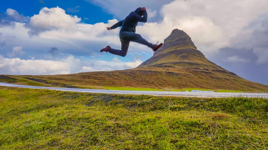 Ujęcie przedstawiające mężczyznę przy górze Kirkjufell.