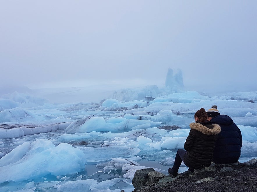 Un couple avec vue sur la lagune de Jökulsárlón dans le sud de l'Islande.