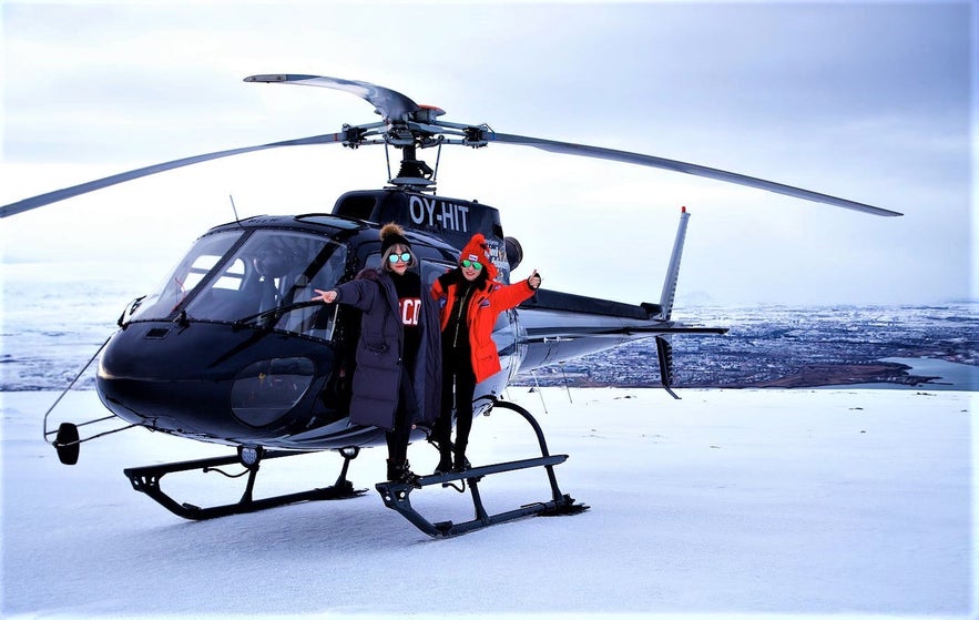 A helicopter lands atop a mountain.