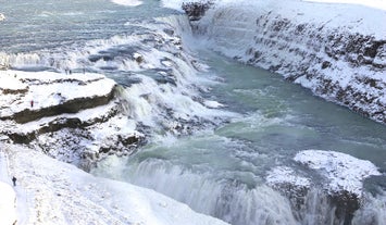 Embark on a snowy journey to witness Gullfoss adorned in winter's icy splendor, a breathtaking scene on the Golden Circle expedition.