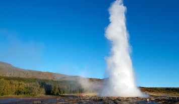 Witness the Strokkur geyser's breathtaking eruption, showcasing the raw power of geothermal activity at the Geysir hot spring area.
