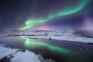 Nordlyset over et snedækket landskab