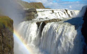 A rainbow forms from the heavy mist of the Gullfoss waterfall in Iceland.