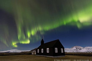 Nordlichter tanzen über der pechschwarzen Kirche von Budir auf Snaefellsnes.