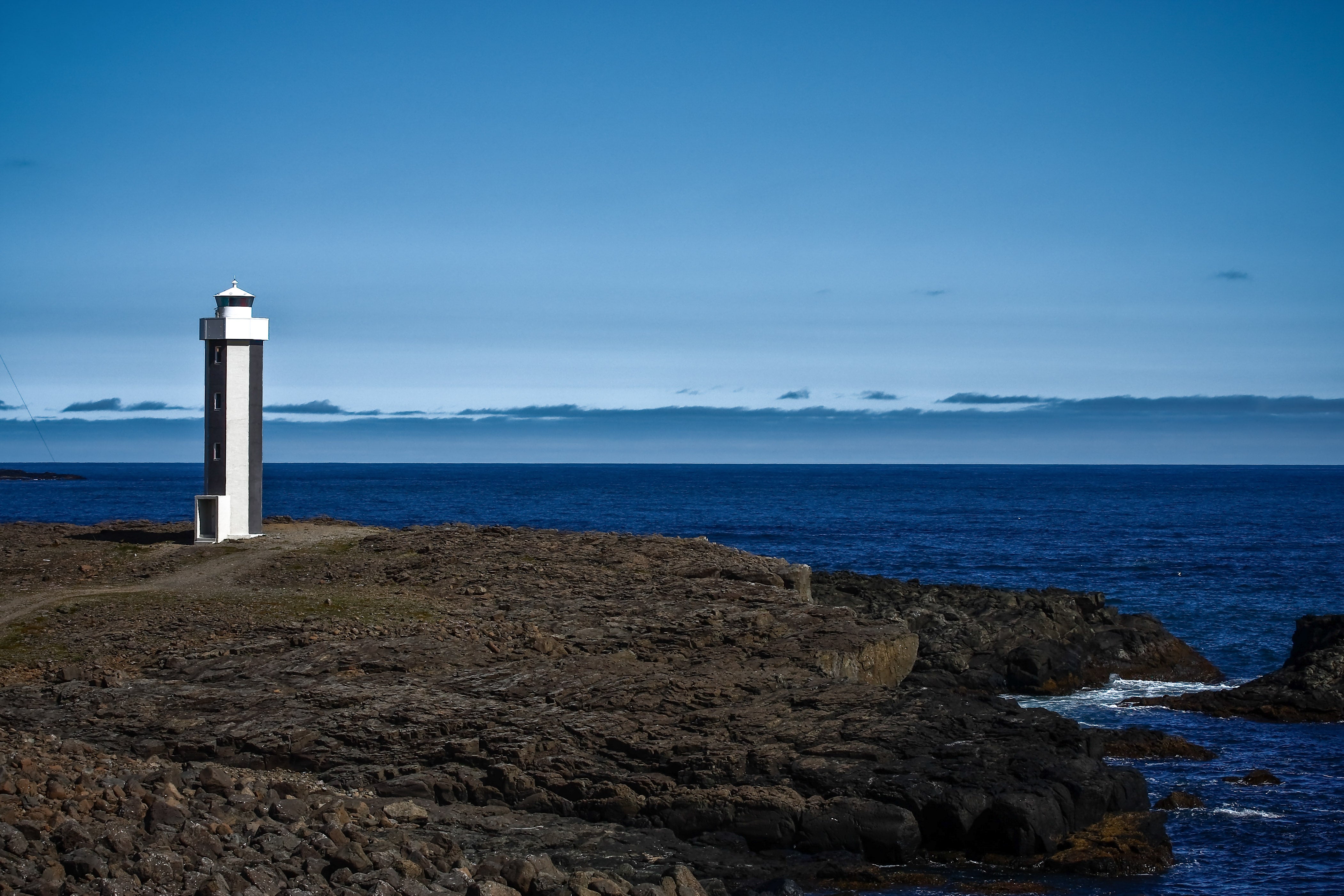 Streitishvarf Lighthouse on Iceland’s eastern coast with dramatic ocean views and rugged cliffs in the background.