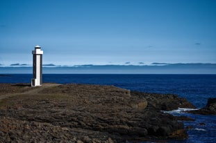 Streitishvarf Lighthouse on Iceland’s eastern coast with dramatic ocean views and rugged cliffs in the background.