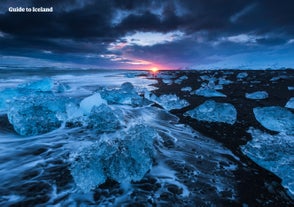 Eisberge glitzern bei Sonnenuntergang am Diamond Beach in der Nähe der Gletscherlagune Jökulsarlon.