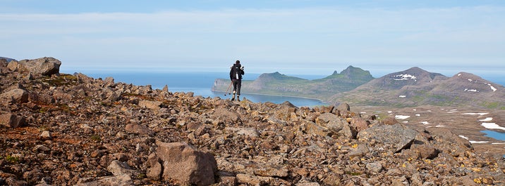 In den Westfjorden spiegeln sich Berge unter der Mitternachtssonne im Meer.