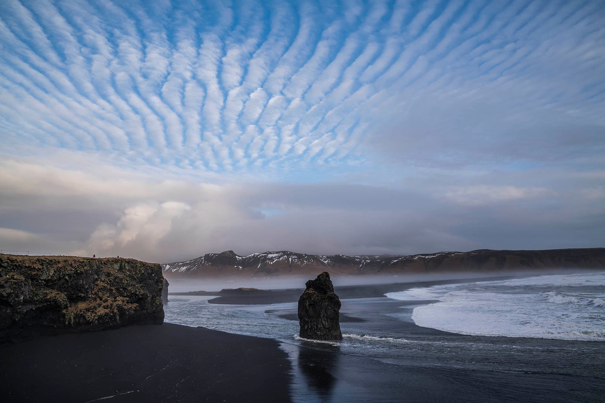 Reynisfjara black sand beach is famous for its ocean waves and cliffs.