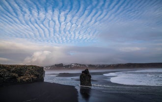 Reynisfjara black sand beach is famous for its ocean waves and cliffs.