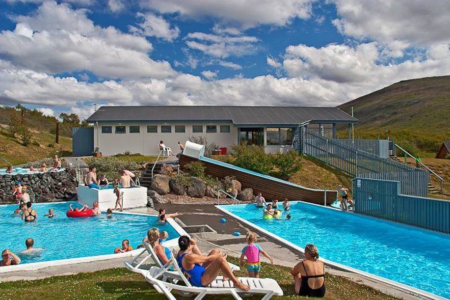 People lounging by the pool in Husafell