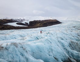 A person stands on the Fjallsjokull glacier in Iceland.