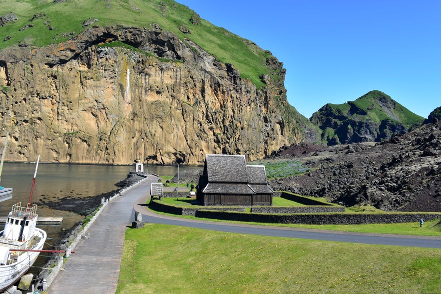Stabkirche und altes Schiff am Hafen von Vestmannaeyjar. 