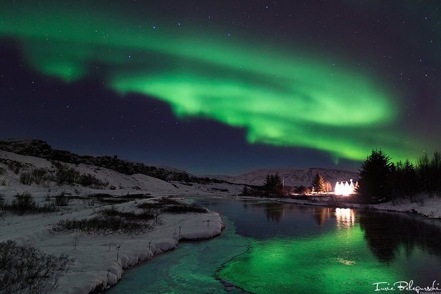 Zorza polarna pięknie odbija się w wodach przecinających Park Narodowy Þingvellir.