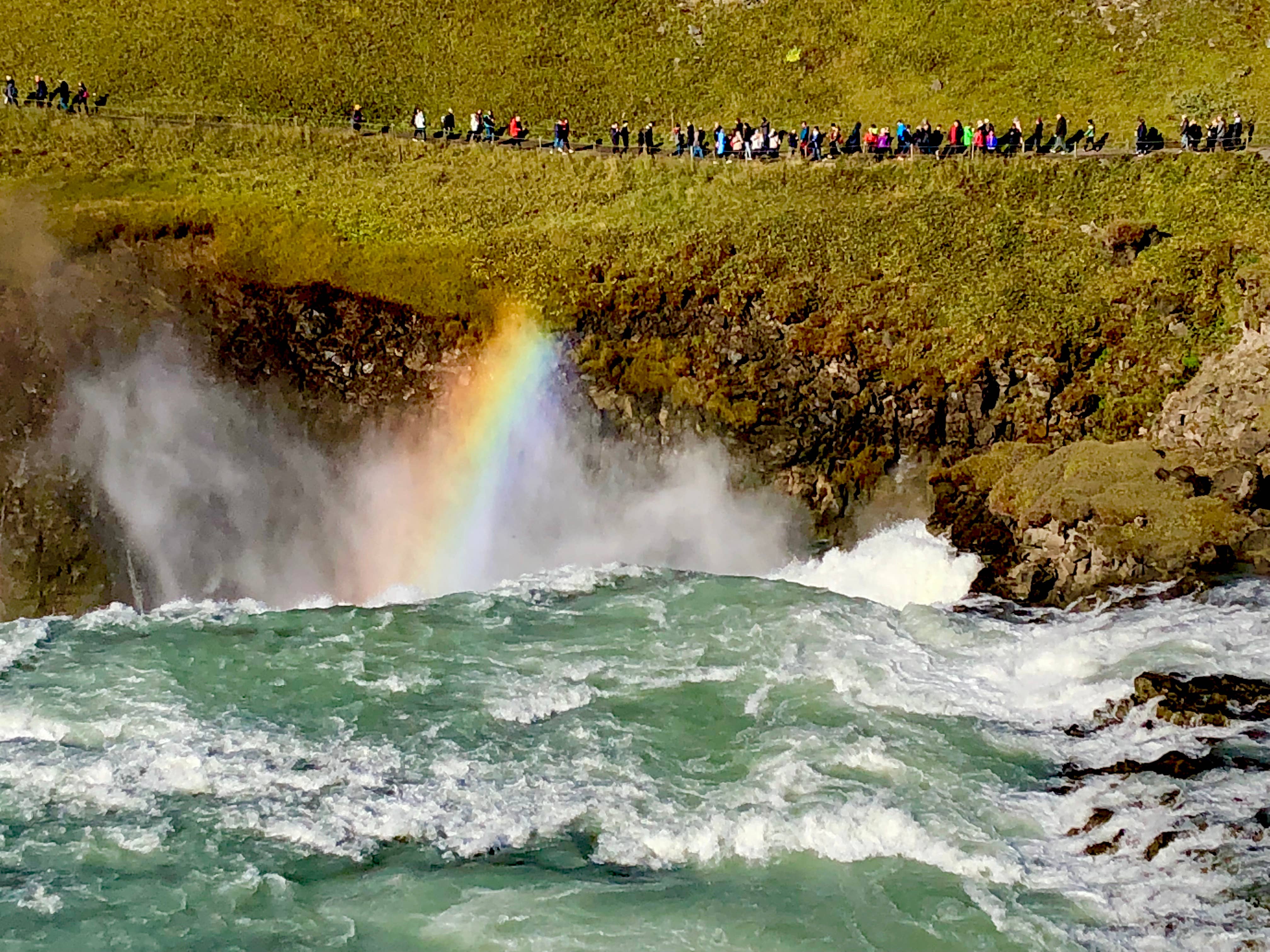 The view from the eastern side of Gullfoss waterfall with a rainbow showing in the mist above it.