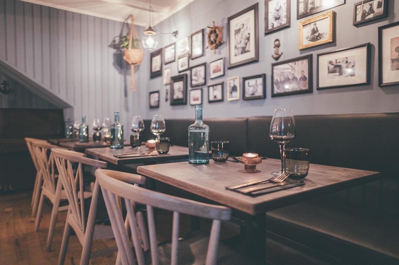 A beautiful spot inside Sjávarpakkhúsið, featuring a wall full of pictures, wooden tables, and cozy benches.