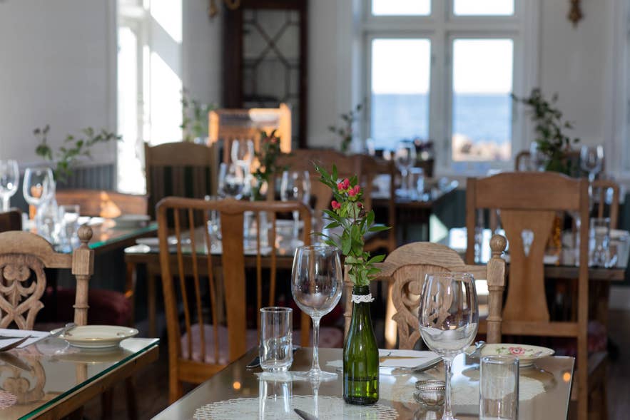 The interior of Bjargarsteinn Mathús, featuring beautifully set tables. The interior of Bjargarsteinn Mathús, featuring beautifully set tables.