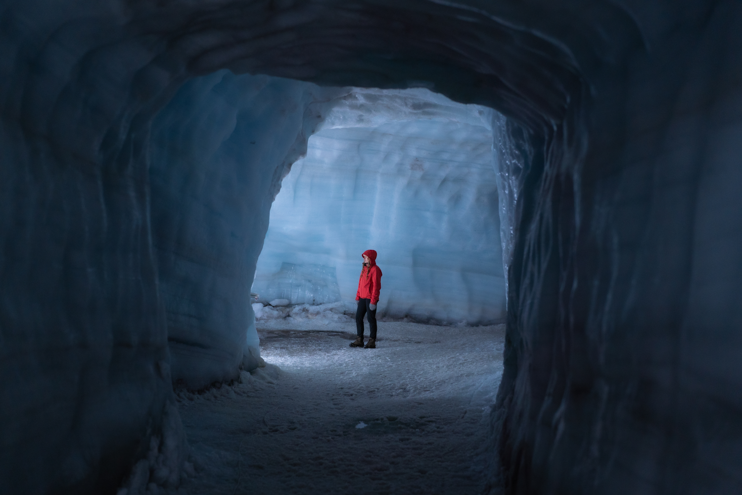 A visitor to Iceland stands in the breathtaking Langjokull Ice Tunnel.