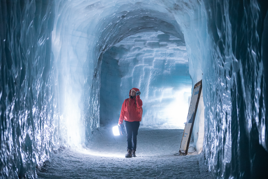 A traveler explores a man-made ice cave in Langjokull Glacier with one of the Icelandic tour companies offering guided glacier experiences.