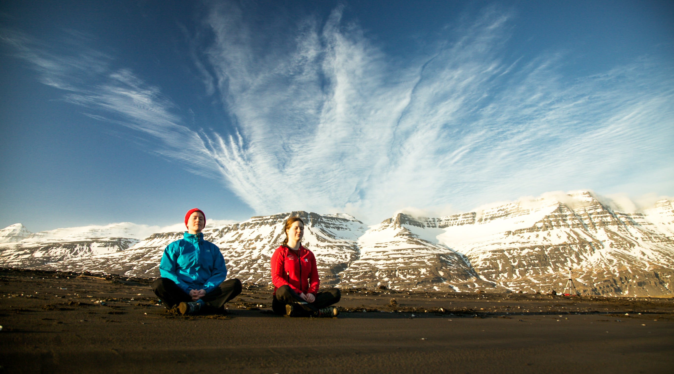 A snow-capped mountain serves as a captivating background to the yoga hiking participants.