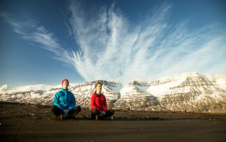 A snow-capped mountain serves as a captivating background to the yoga hiking participants.