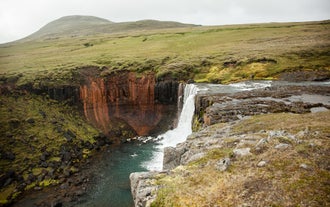 A waterfall runs down into a canyon in East Iceland.