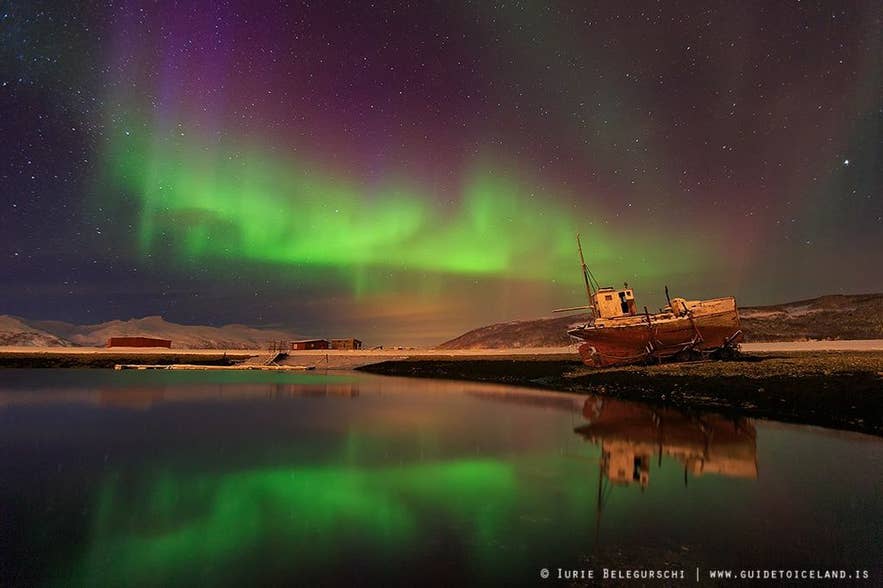 Nordlichter über einem verlassenen Fischerboot in den Westfjorden Islands.