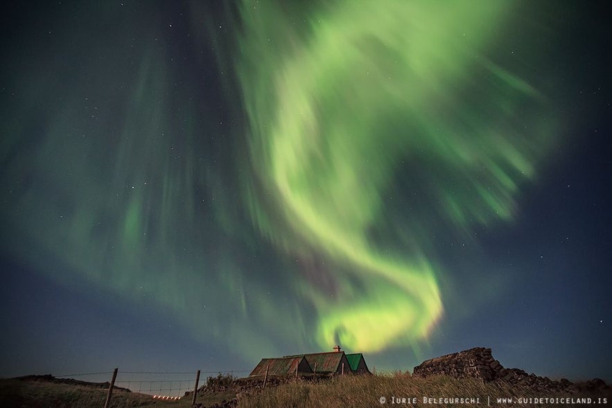 The Northern Lights above an old turf house church in rural Iceland.