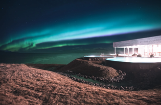 The aurora borealis swirls above the GeoSea Baths in Husavik.