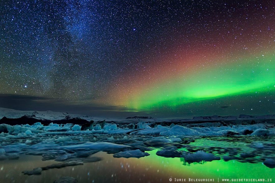 Sterne und Polarlichter spiegeln sich im tiefen See von Jökulsárlón