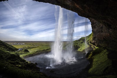 Widok zza kaskadowych wód Seljalandsfoss na południowym wybrzeżu Islandii.