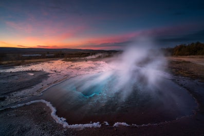 Gejzer Strokkur wyrzucający z siebie potężny słup gorącej wody sięgający kilkunastu metrów.