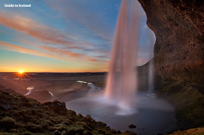 La splendida cascata di Seljalandsfoss immersa nel sole di mezzanotte.