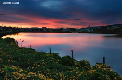 Upea auringonlasku viehättävän Reykjavíkin kaupungin yllä.