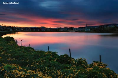 Upea auringonlasku viehättävän Reykjavíkin kaupungin yllä.