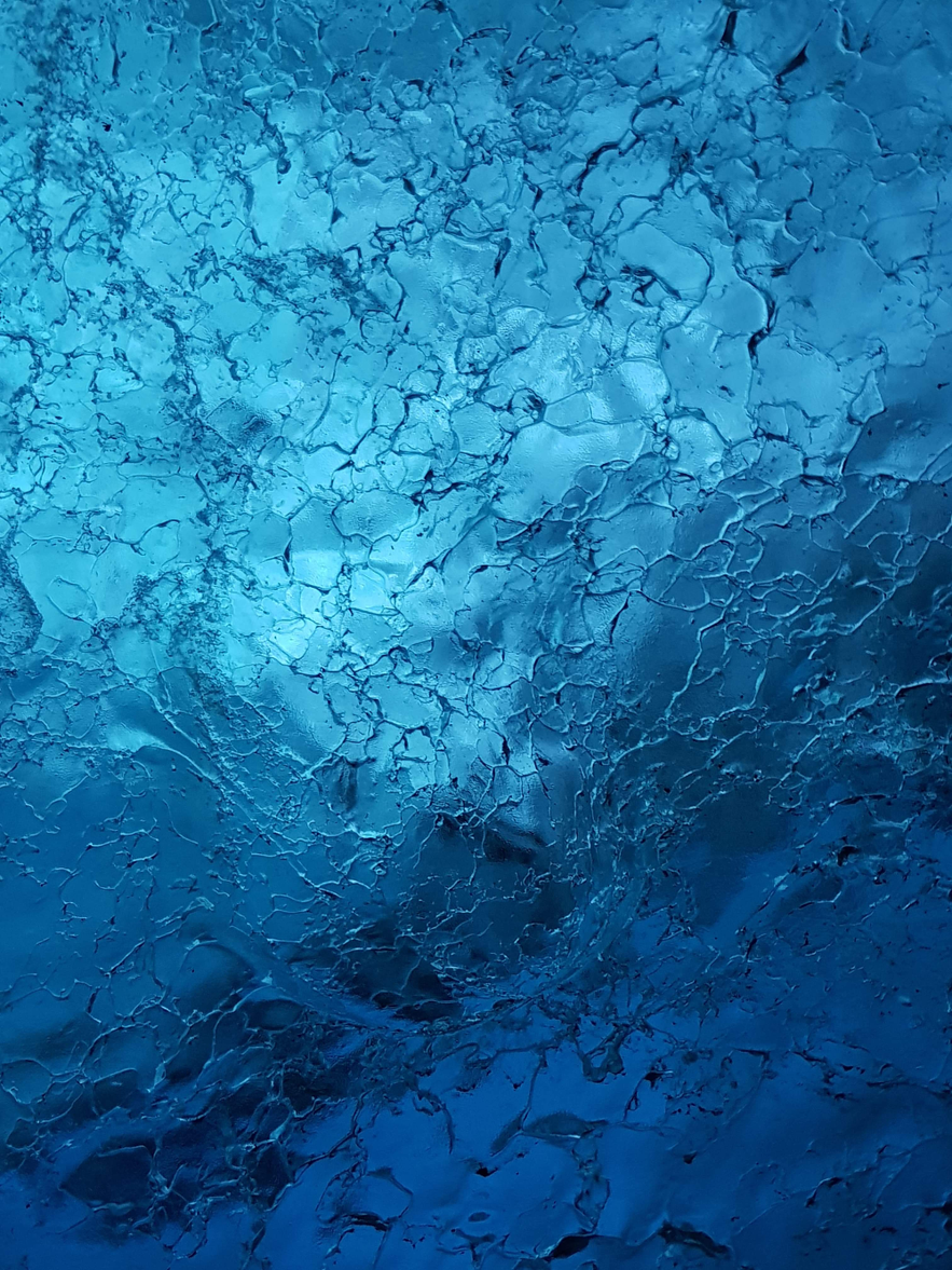 Feine Musterung in der Eiswand der Gletscherhöhle auf Island.