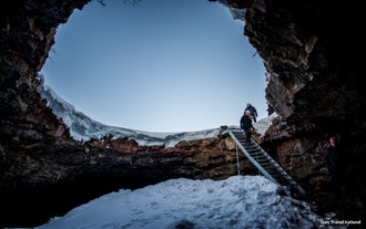 Guests going down the stairs on the mouth of the Lofthellir ice cave's entrance.