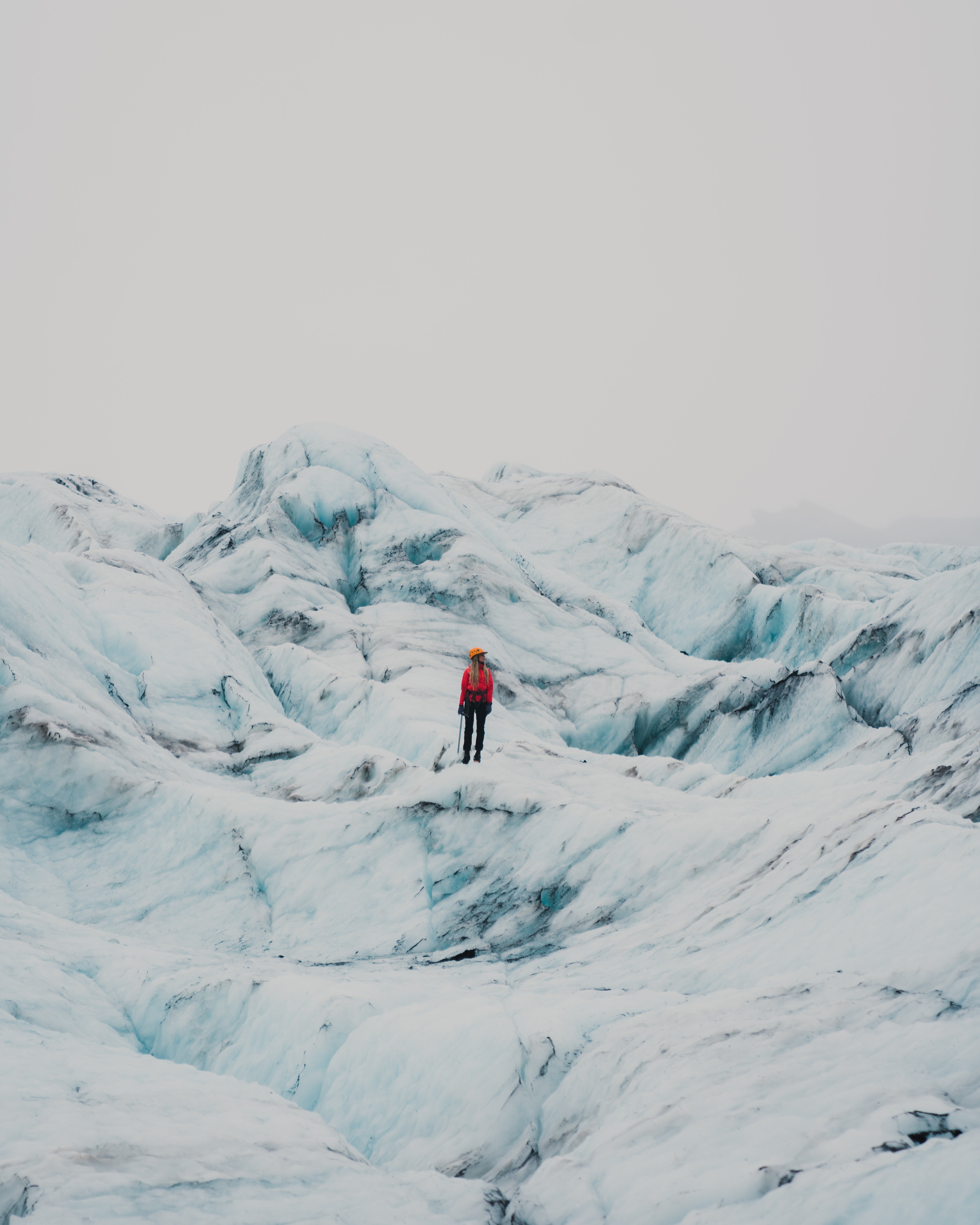 A person stands in the middle of the icy expanse of Solheimajokull glacier on a tour in Iceland.