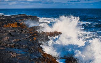 Powerful Atlantic waves crash against coastal cliffs on the Reykjanes Peninsula, a dramatic highlight of any Reykjanes tour.
