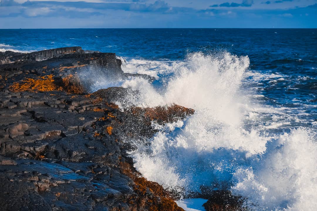 Powerful Atlantic waves crash against coastal cliffs on the Reykjanes Peninsula, a dramatic highlight of any Reykjanes tour.